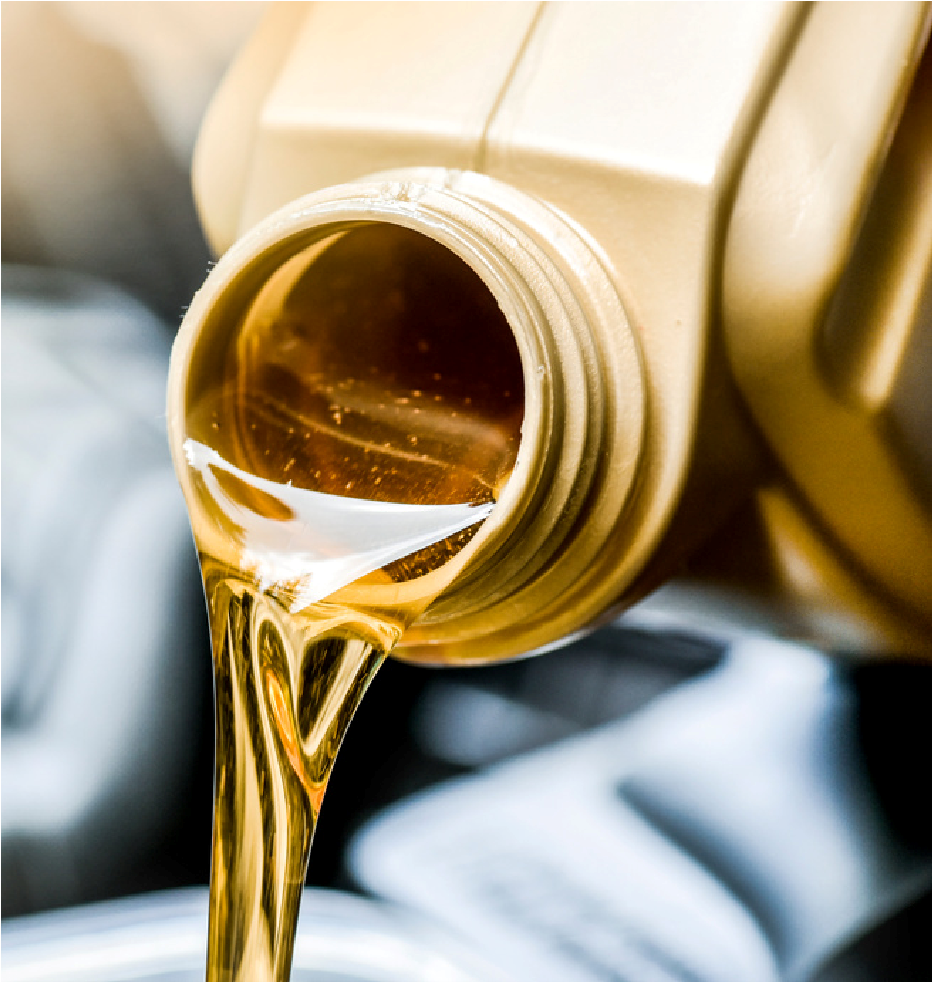 Amber motor oil pouring from a gold container into a vehicle engine