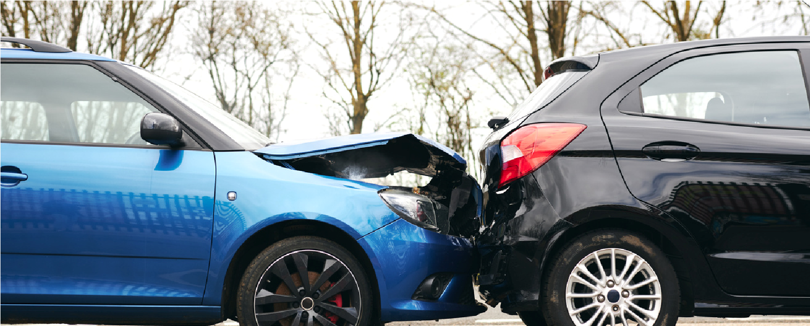 Blue car rear-ended by black SUV in a road crash scene