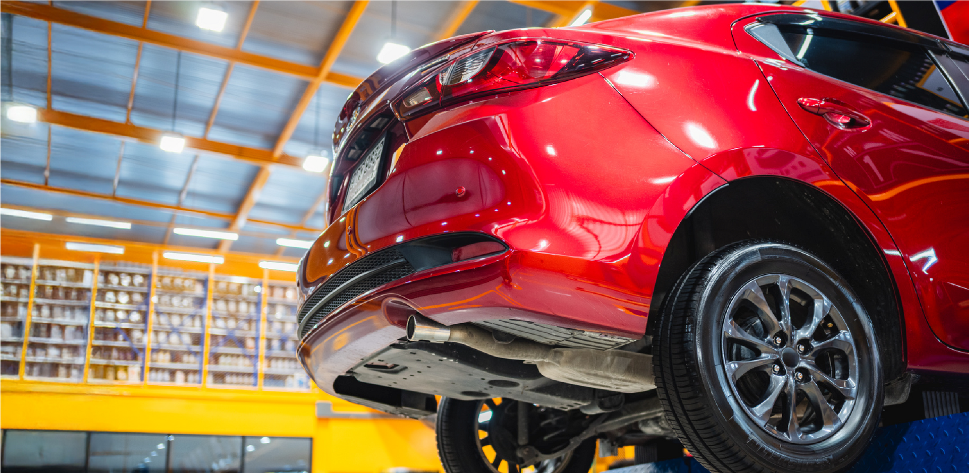 Red car on an assembly line in a brightly lit automotive factory