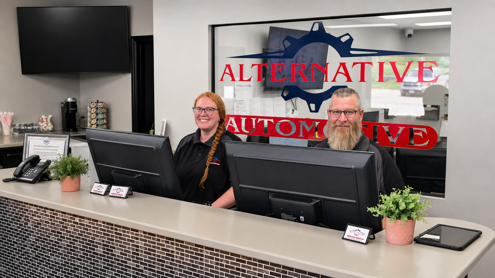 Man standing behind a front desk with computer monitors in a modern lobby