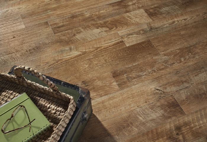 Wooden floorboards with a woven basket and a green book.