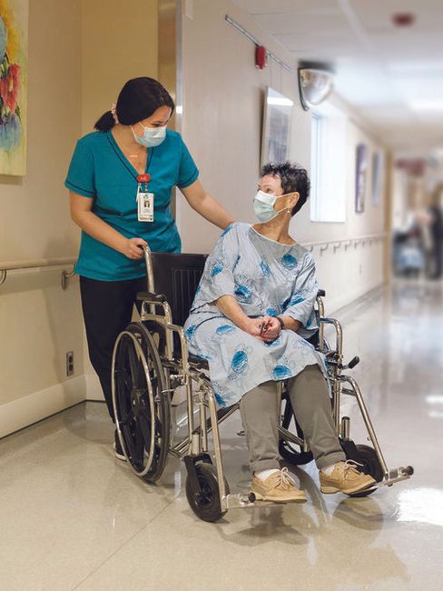 Nurse assists patient in wheelchair Nurse assists patient in wheelchair