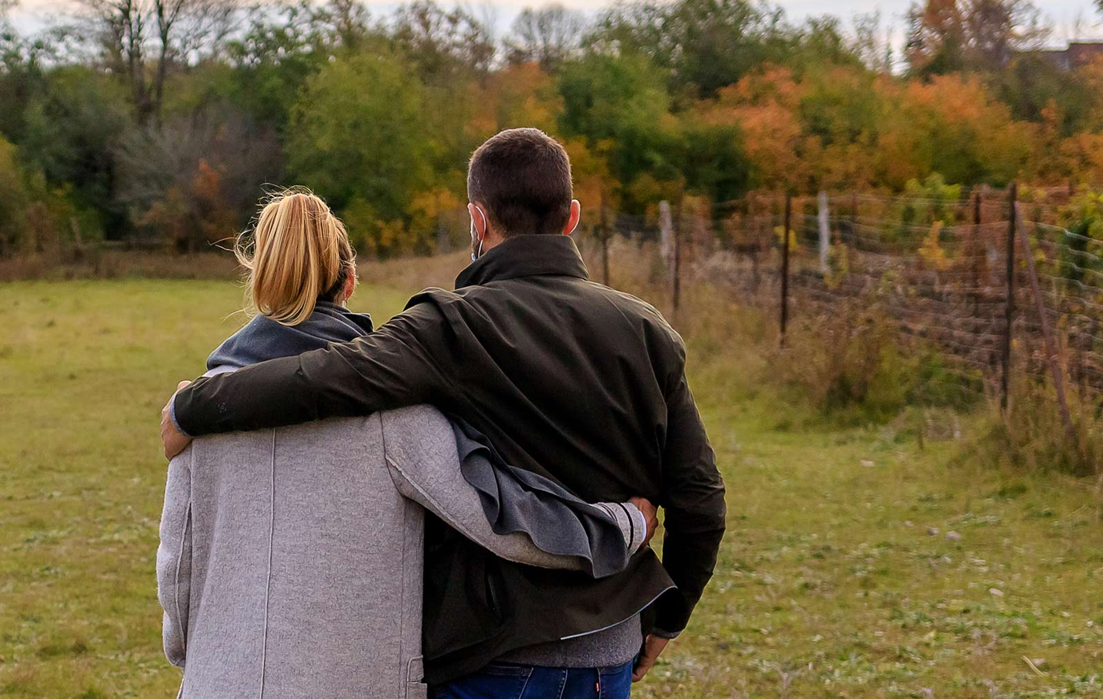 A couple shown from back embrace A couple shown from back embrace