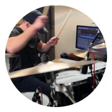 Drummer playing drums in a recording studio. Black and white photo.