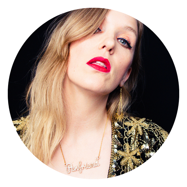 Blonde woman in gold jacket, red lipstick,