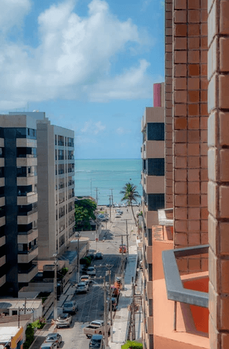 Uma vista de uma rua da cidade e do oceano de uma varanda.
