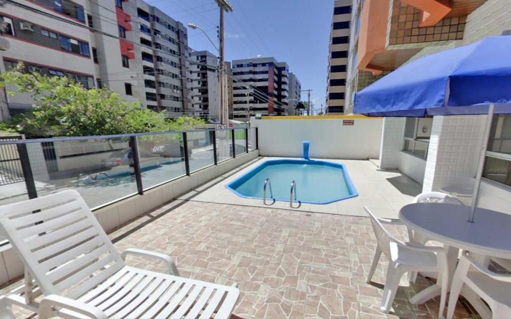 Há uma piscina no quintal de um prédio.