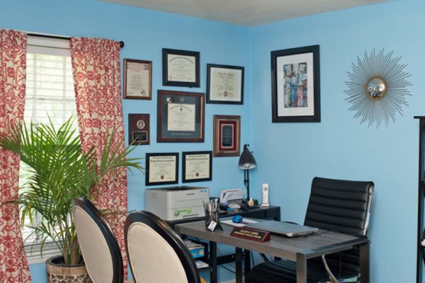 A room with blue walls and a desk with a laptop on it