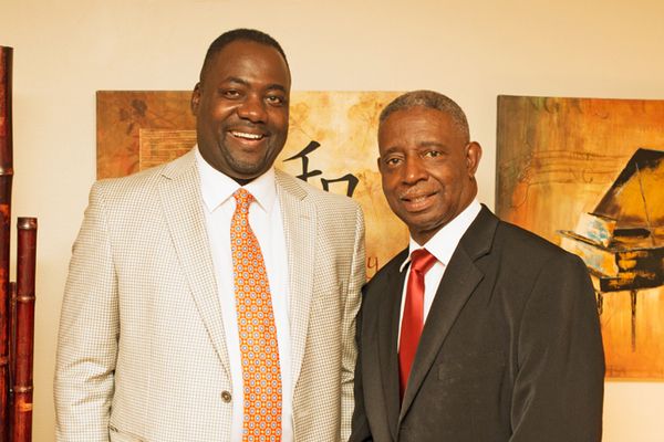 Two men in suits and ties are posing for a picture