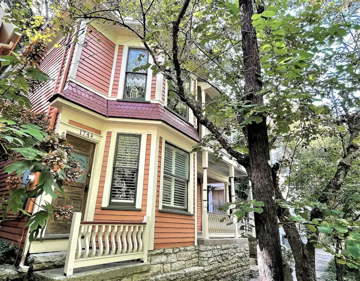 a small house with a porch is surrounded by trees .