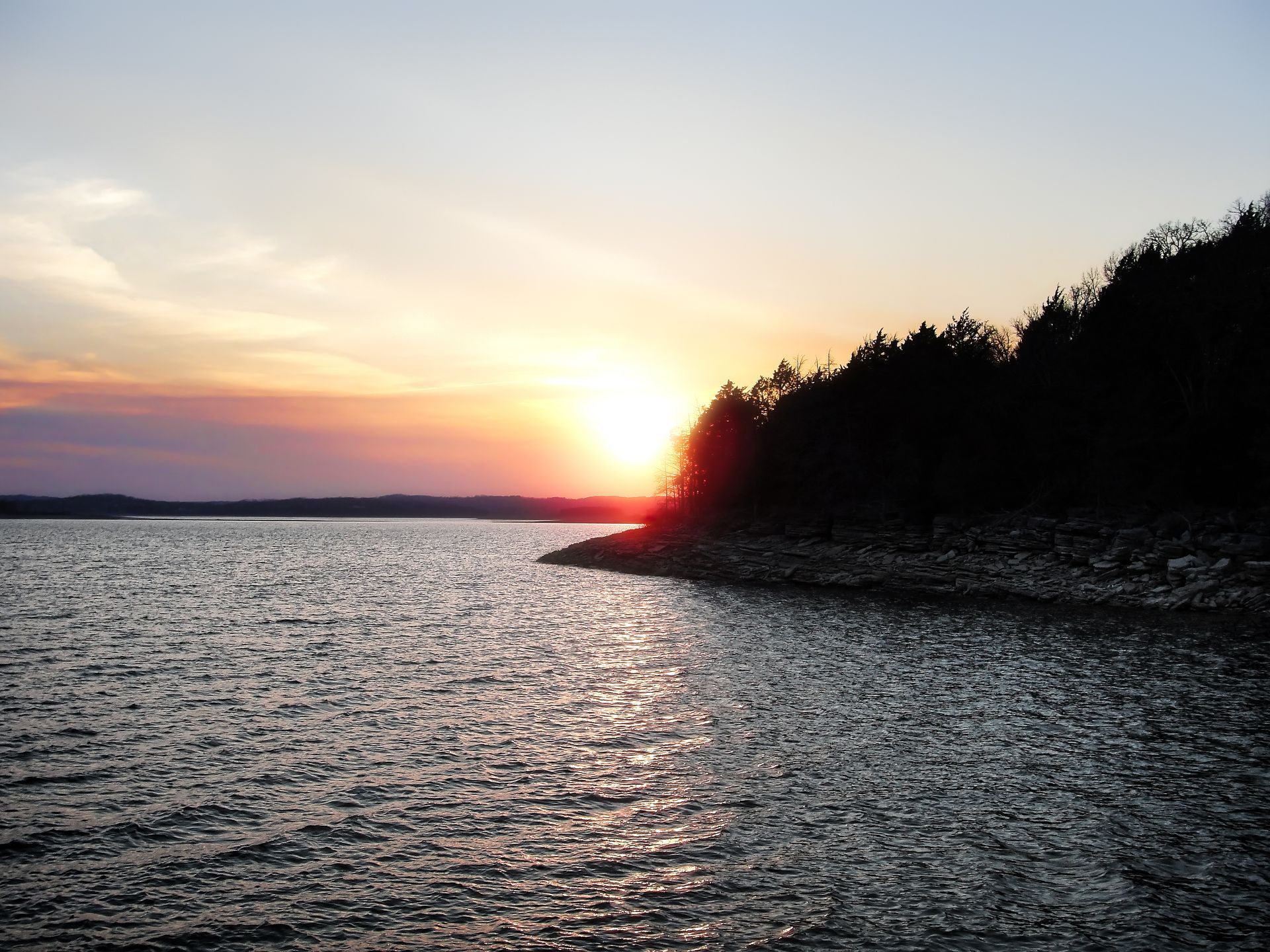 the sun is setting over a body of water