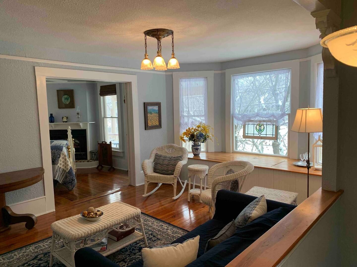 a living room with a blue couch , rocking chairs , and a coffee table .