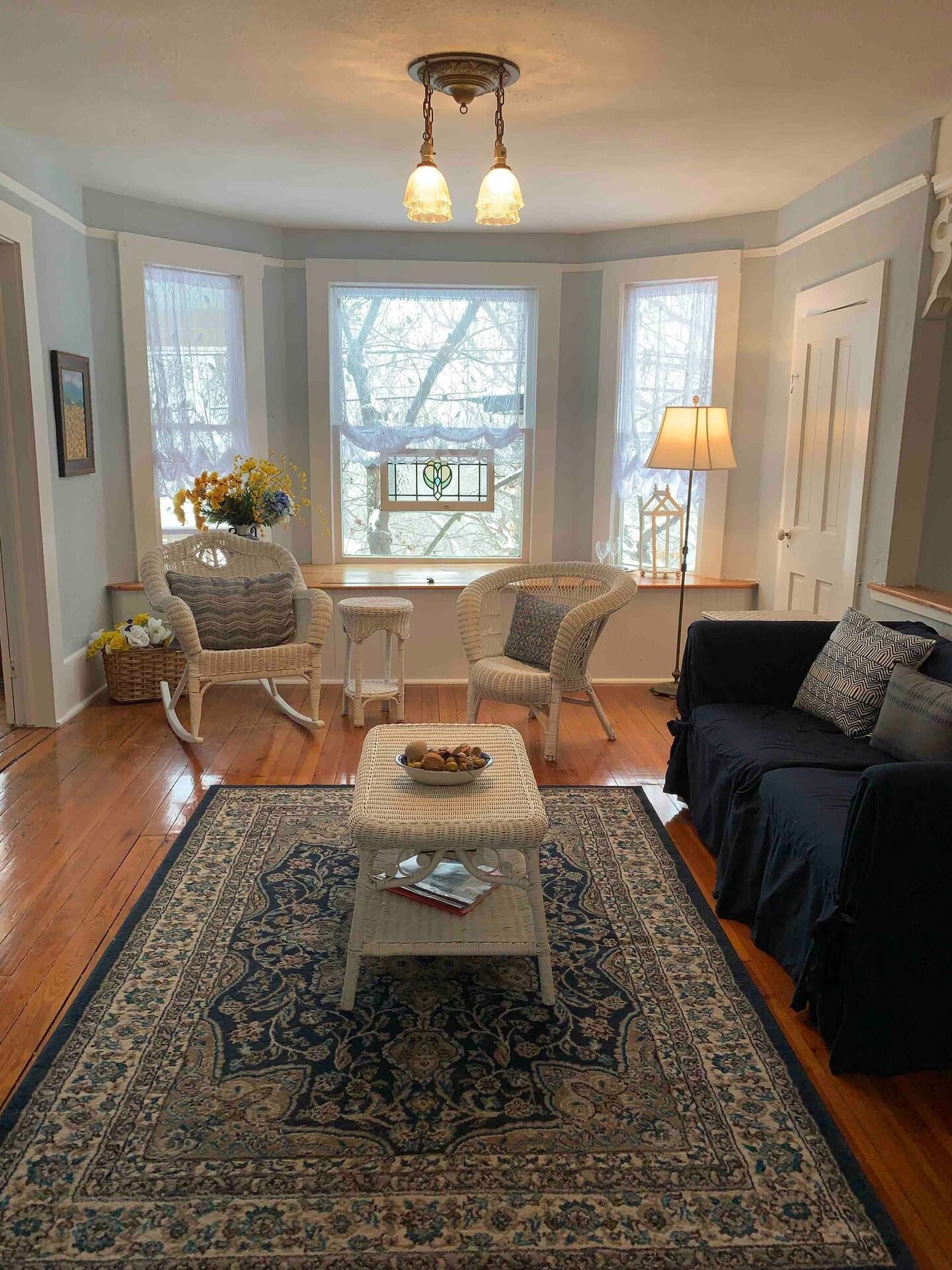 a living room with a couch , chairs , and a rug .