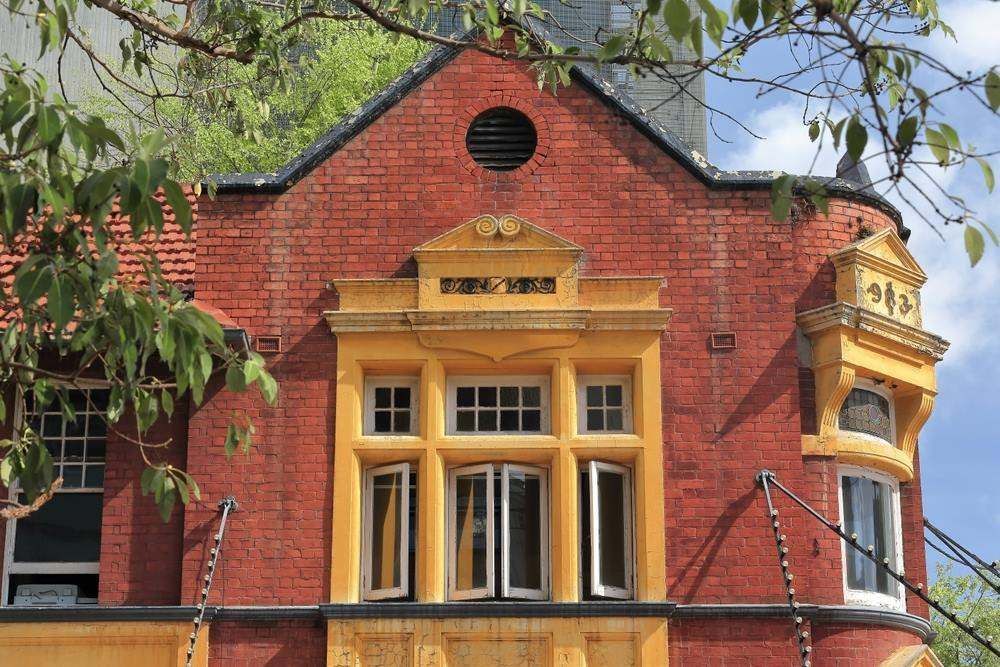 Red-brick Building Facade With Yellow-trimmed Windows — Maid In Bowral in Liverpool, NSW