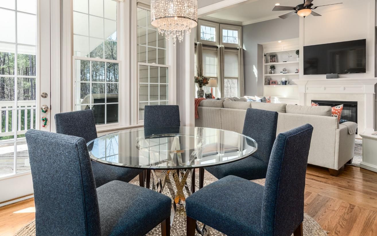 A Dining Room with A Glass Table and Blue Chairs — Maid In Bowral in Robertson, NSW