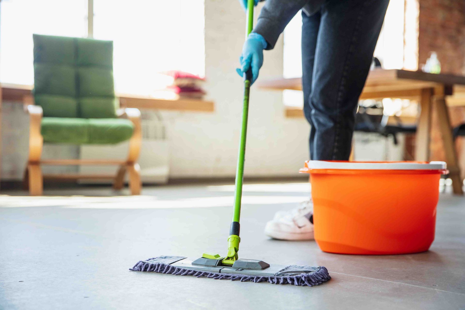 A Person Is Cleaning the Floor with A Mop and Bucket — Maid In Bowral in Goulburn, NSW