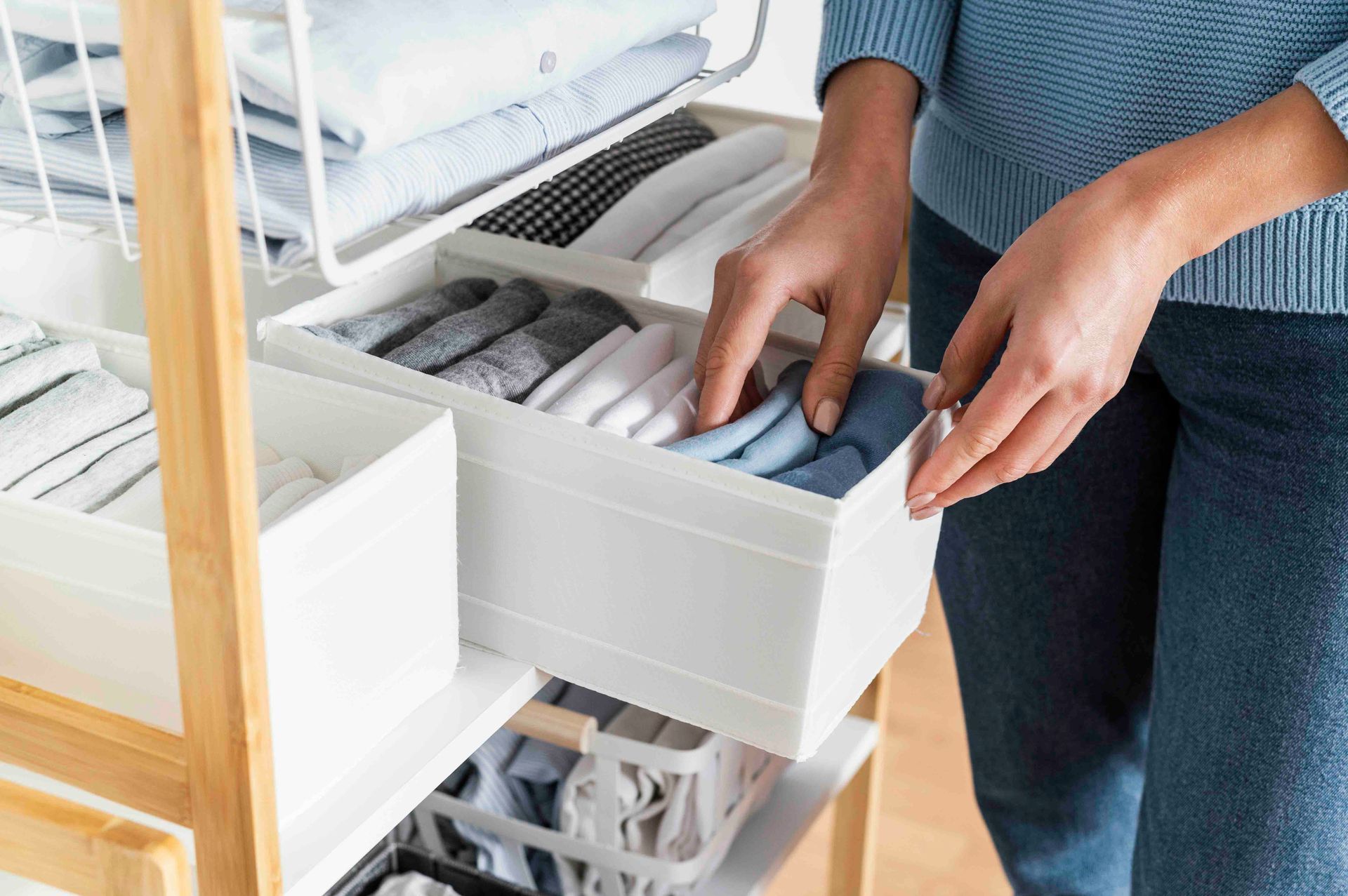 A Woman Is Taking Clothes out Of a Drawer in A Closet — Maid In Bowral in Moss Vale, NSW