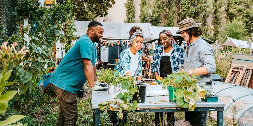 A group of people are standing around a table in a garden.