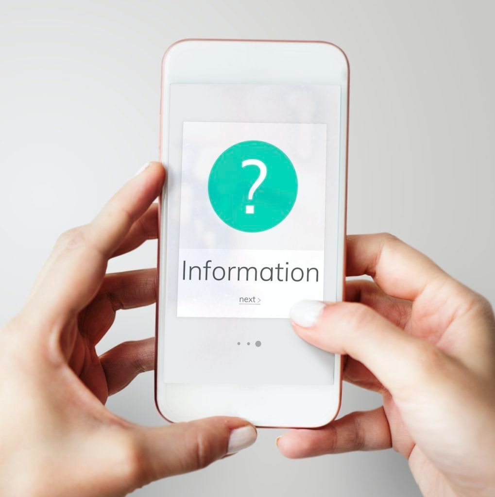 A person is holding a cell phone with information on the screen