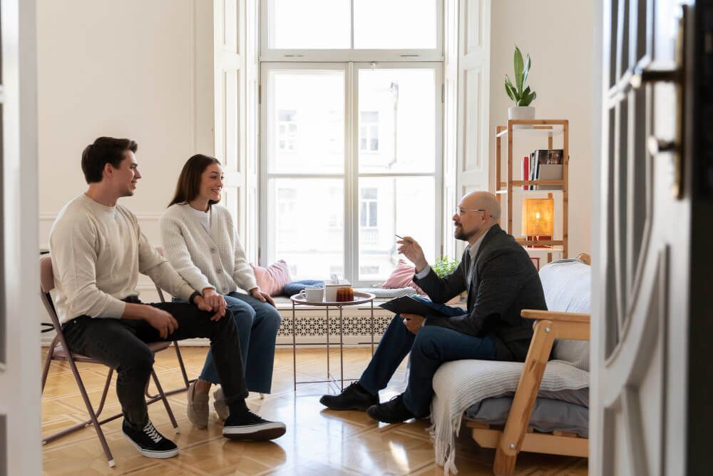 A group of people are sitting in a living room talking to each other.