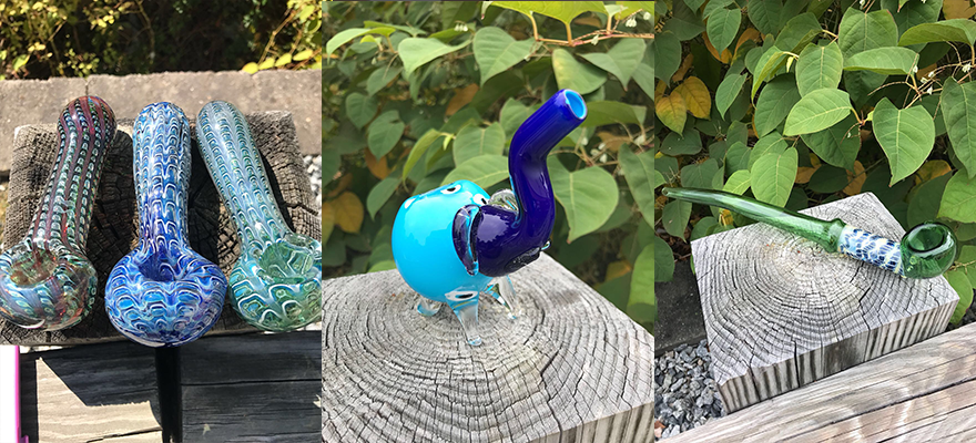 A group of glass pipes sitting on top of a wooden stump