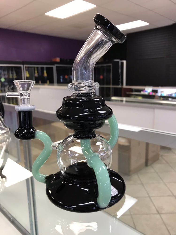 A glass pipe is sitting on a glass shelf in a store
