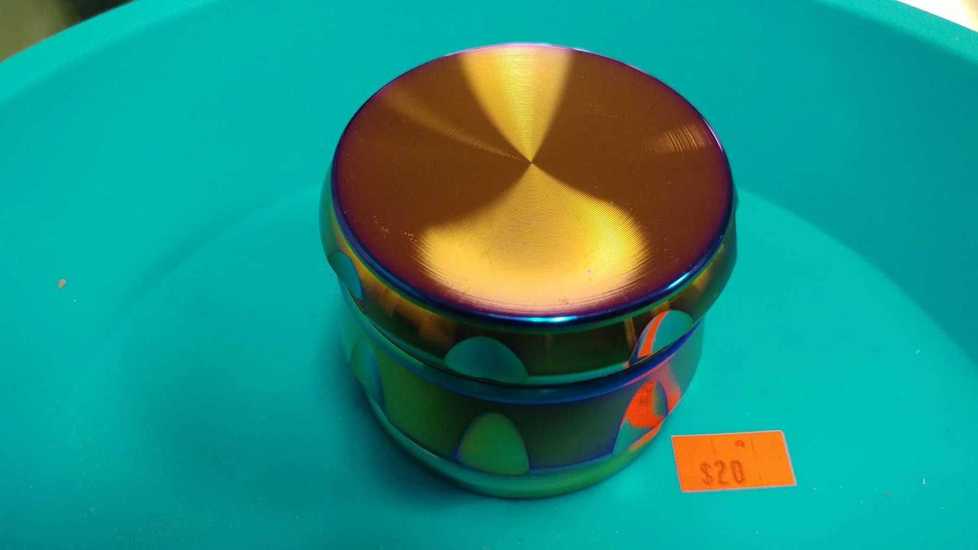 A rainbow colored grinder is sitting on top of a blue tray