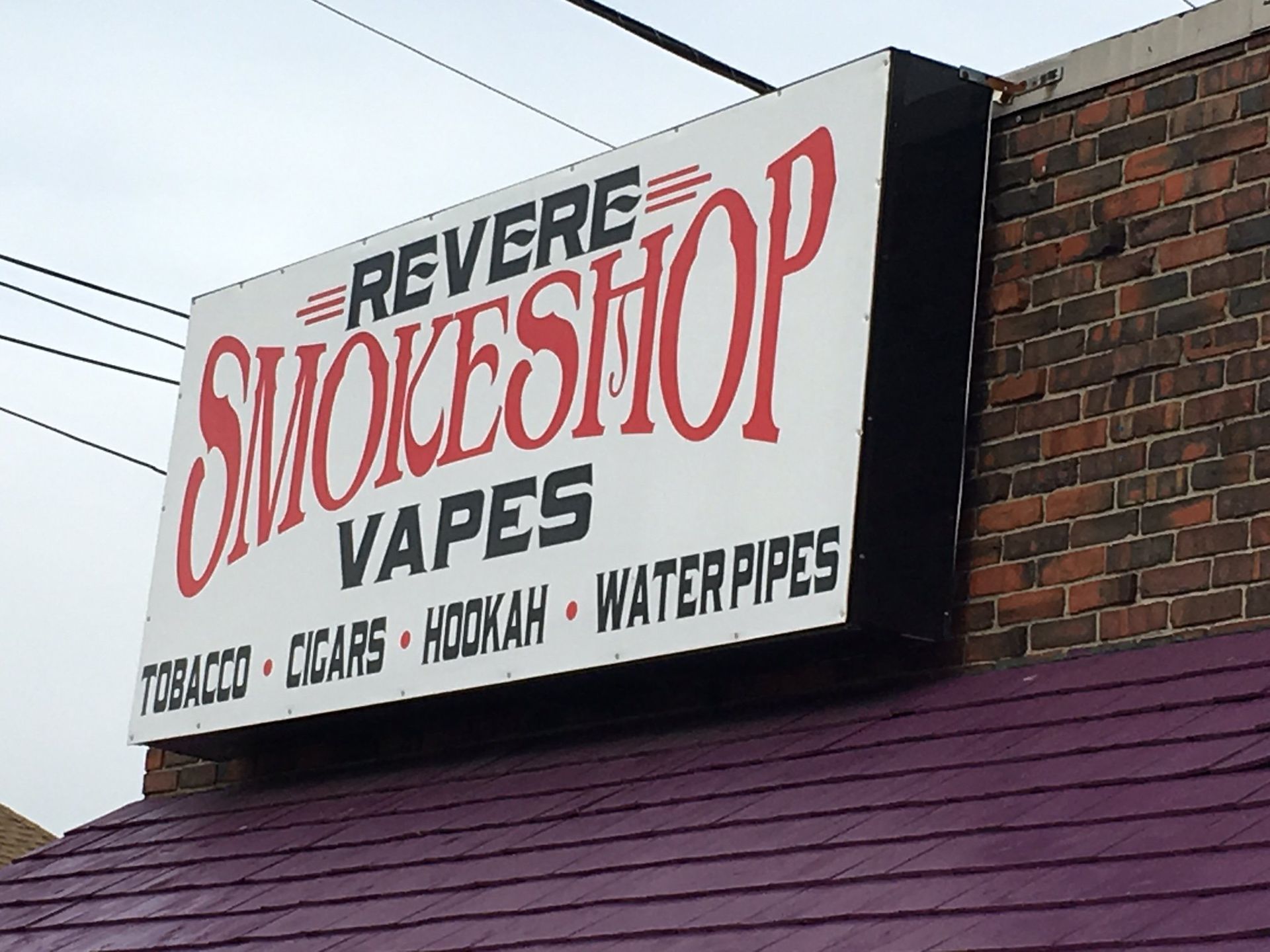 A sign for revere smokeshop vapes tobacco cigars hookah water pipes