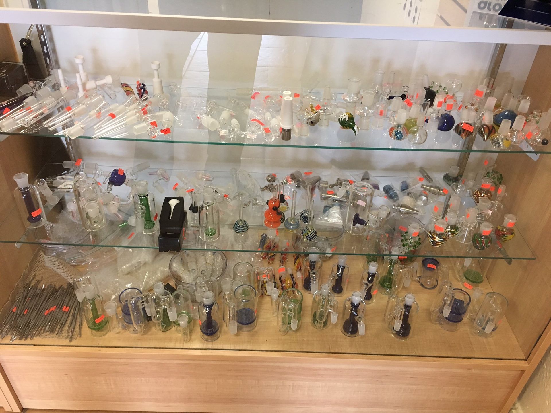 A glass display case filled with a variety of glass pipes