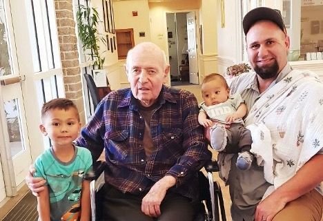 A man in a wheelchair is posing for a picture with two children.