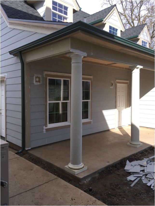 A white house with a covered porch and columns