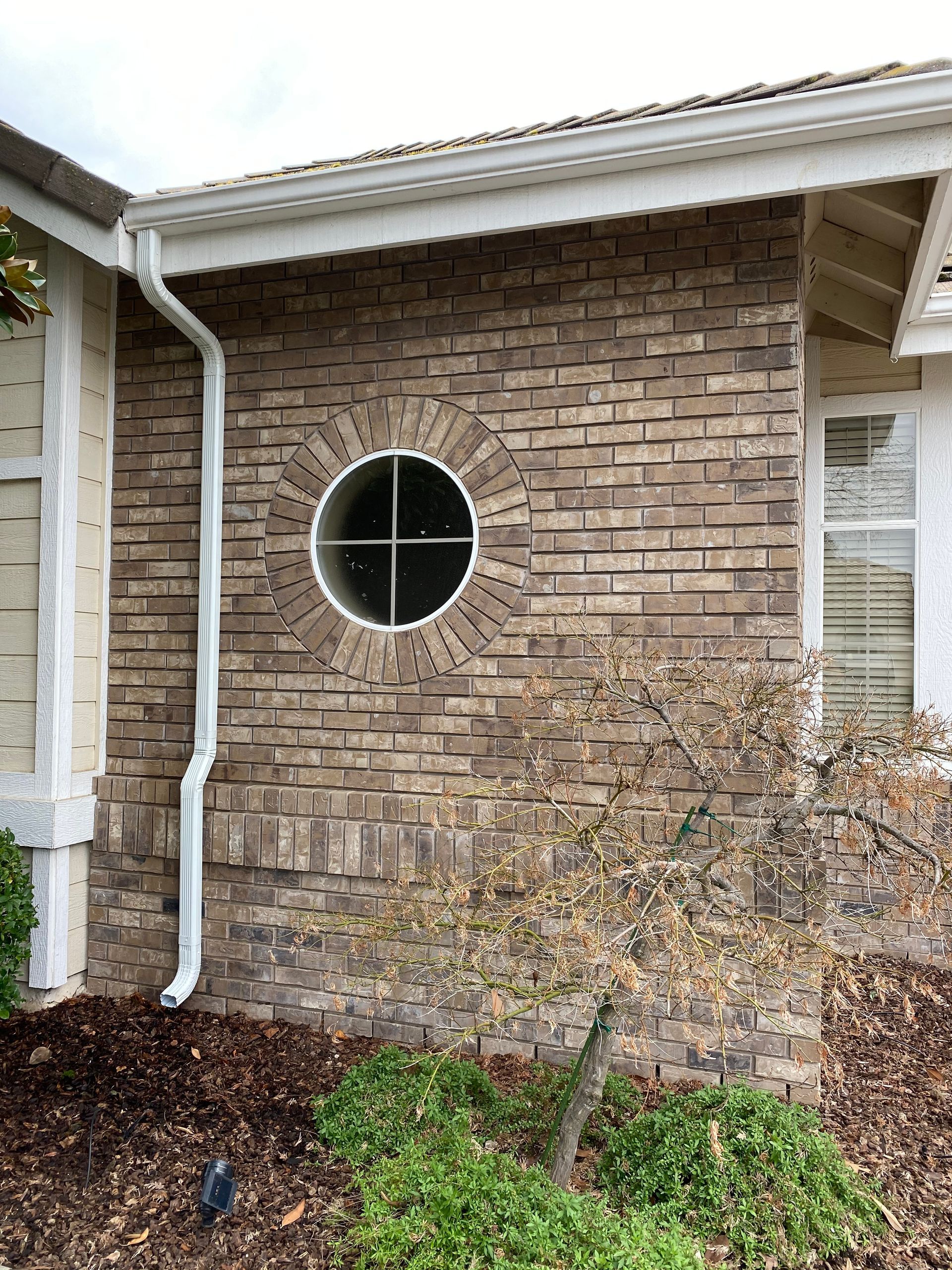 A brick building with a round window on the side of it.