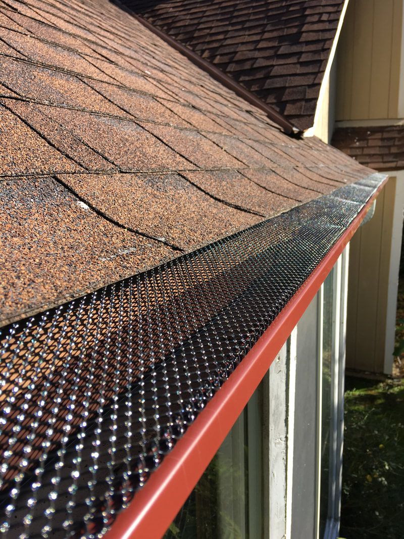 A close up of a gutter on the side of a house.
