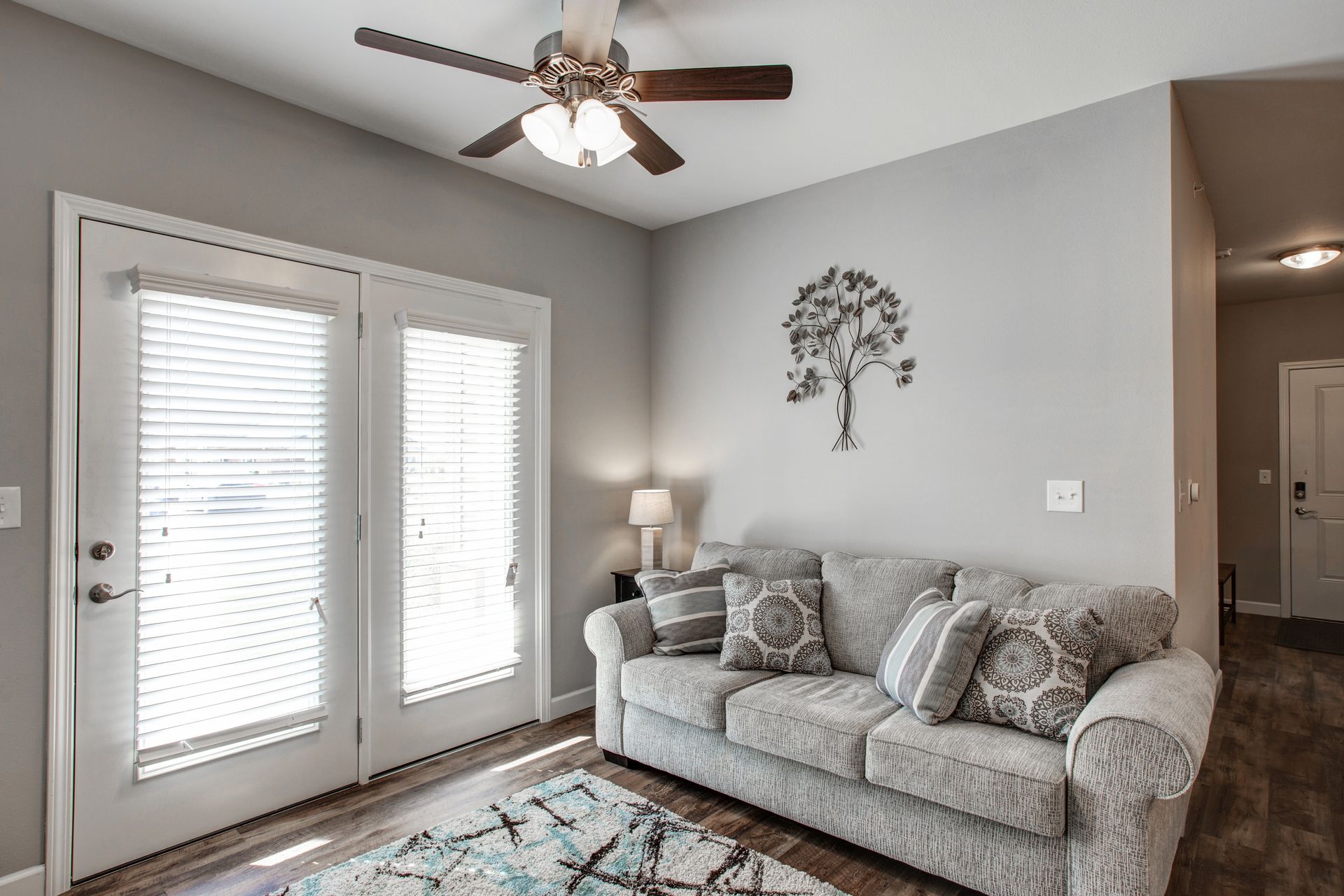 A living room with a couch and a ceiling fan.