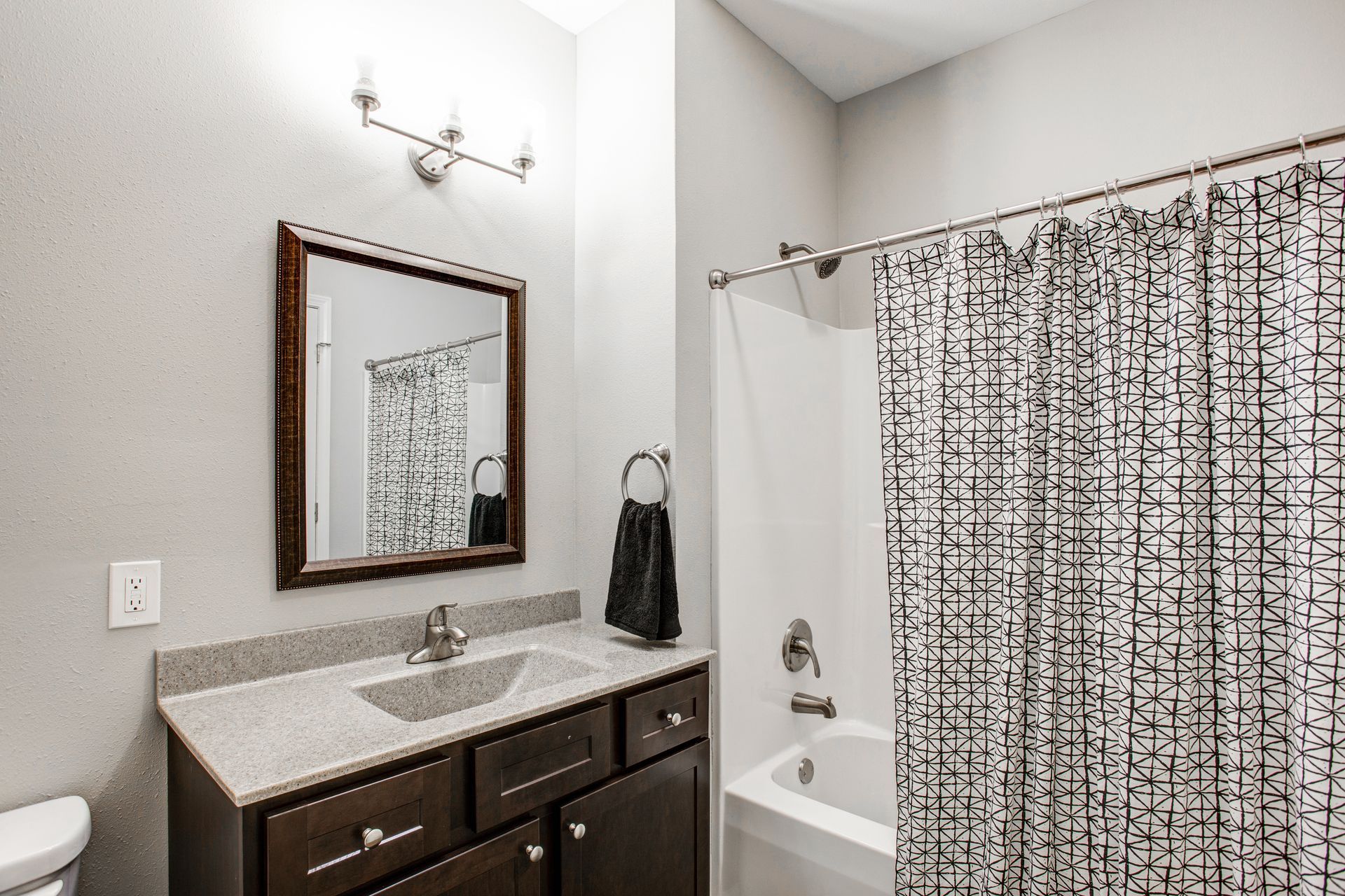 A bathroom with a sink , toilet , shower and shower curtain.