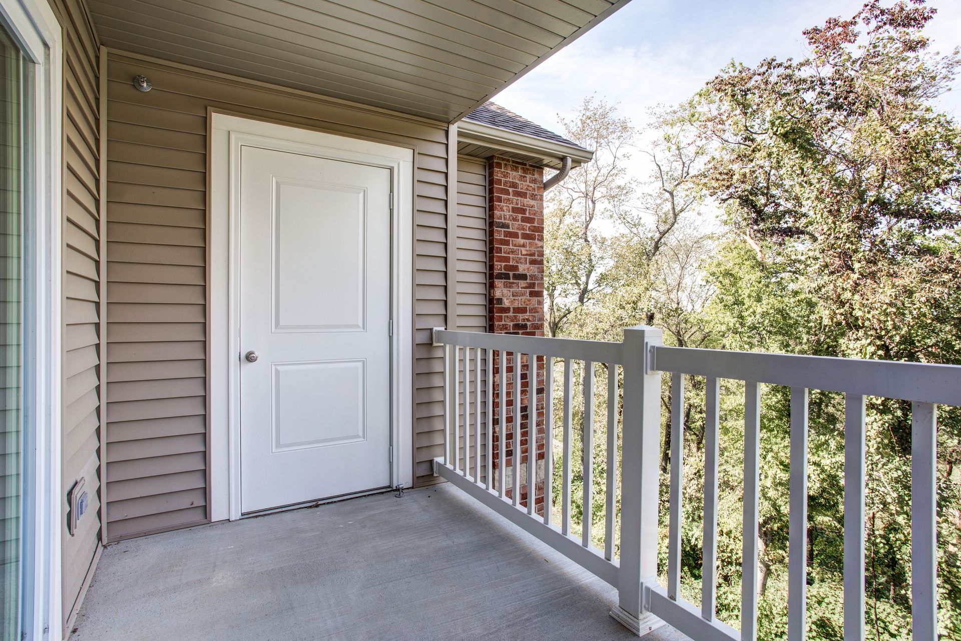 A balcony with a white railing and a white door
