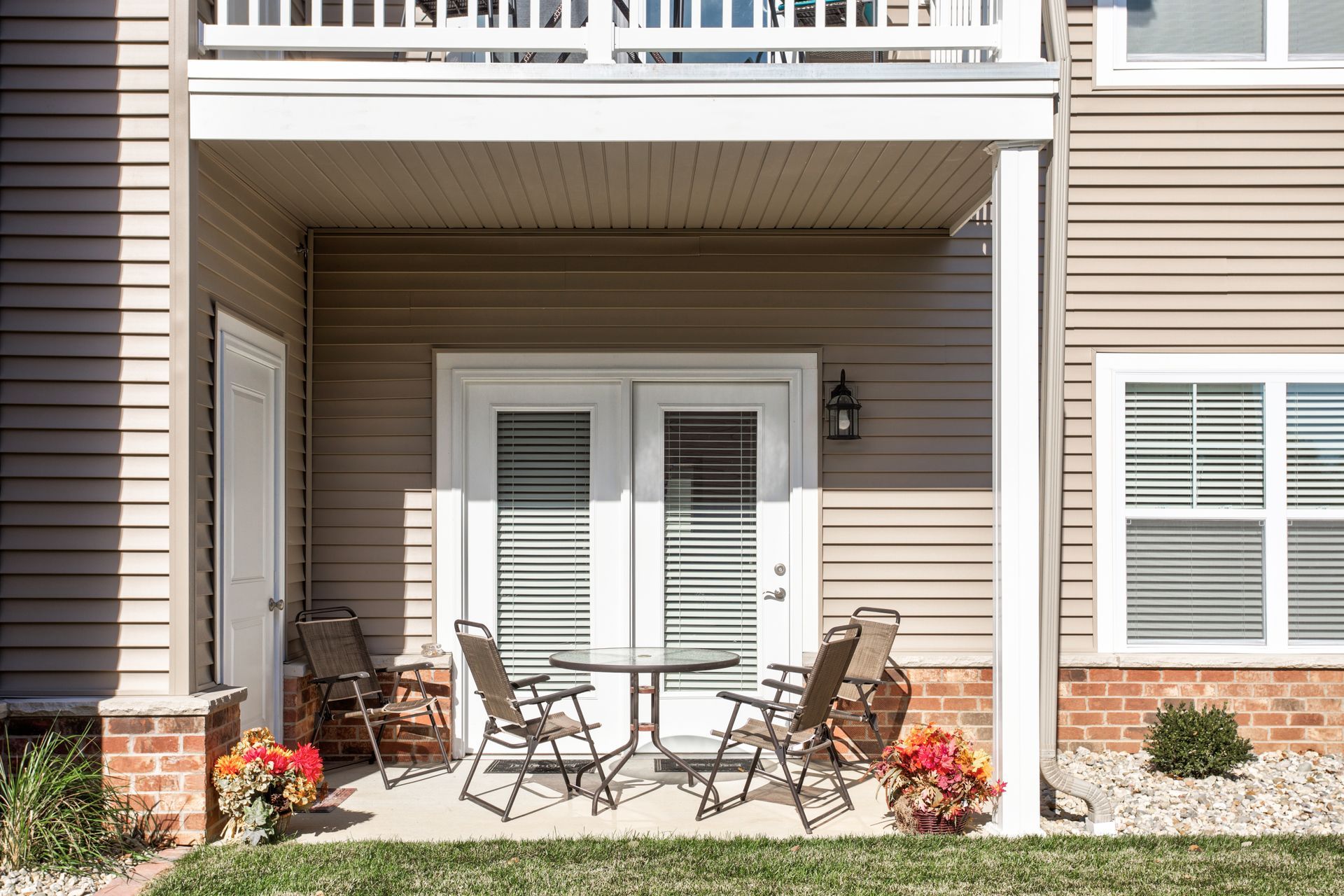 A patio with a table and chairs in front of a house.