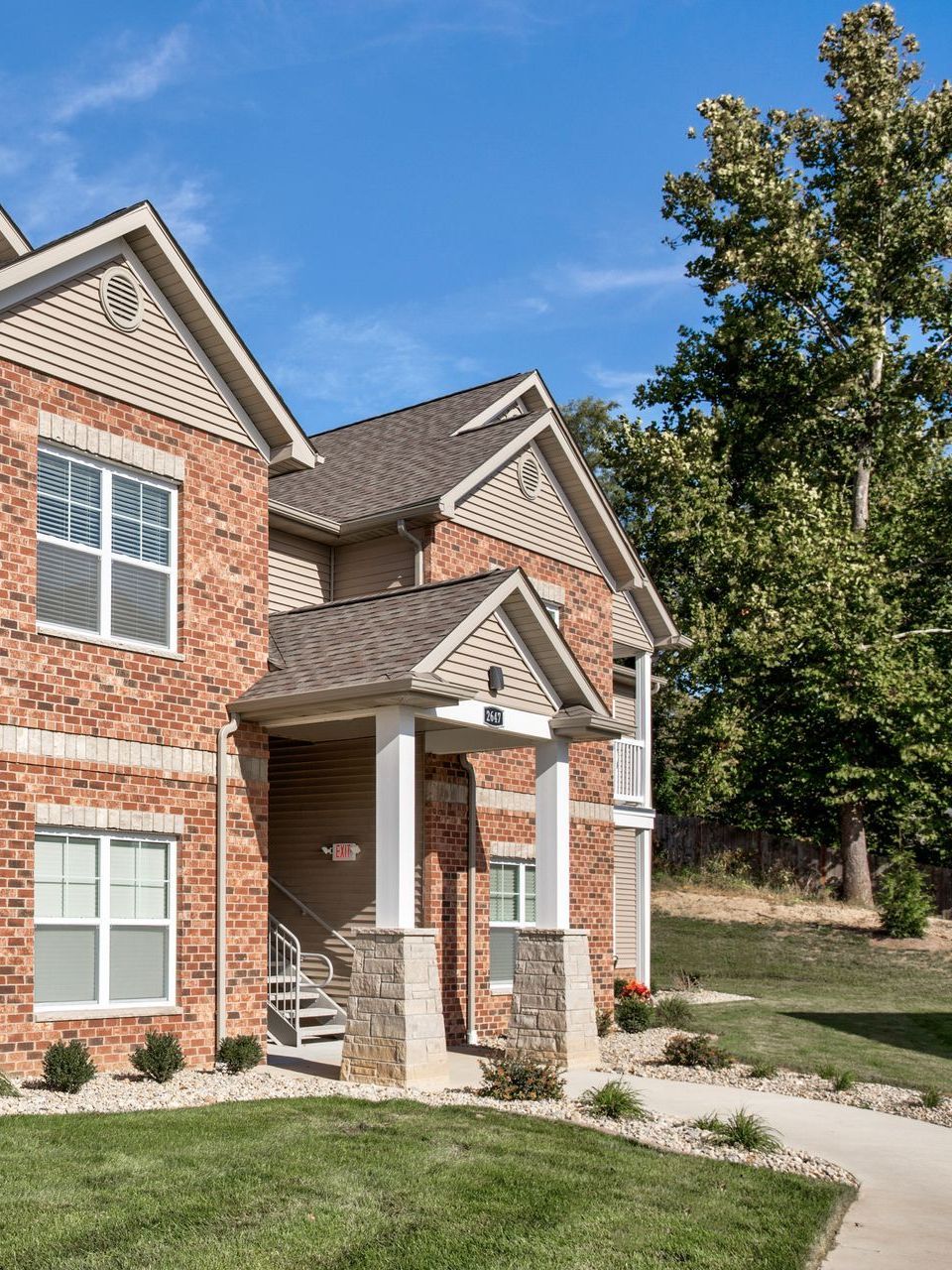 A large brick house with a porch and stairs