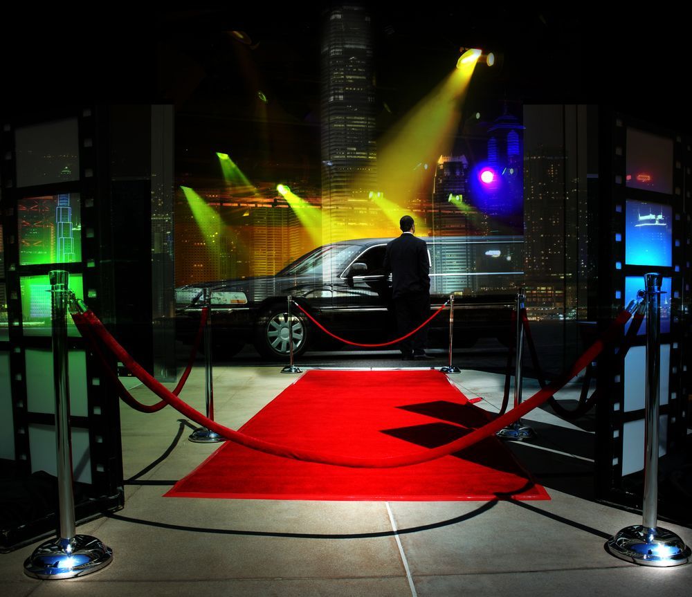 A Man Is Standing In Front Of A Car On A Red Carpet — Pink Up Gold Coast in Southport, QLD