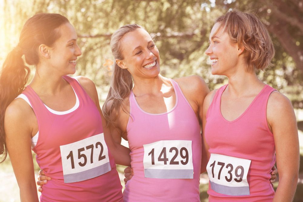 Three Women In Pink Tank Tops Are Standing Next To Each Other And Smiling — Pink Up Gold Coast in Southport, QLD