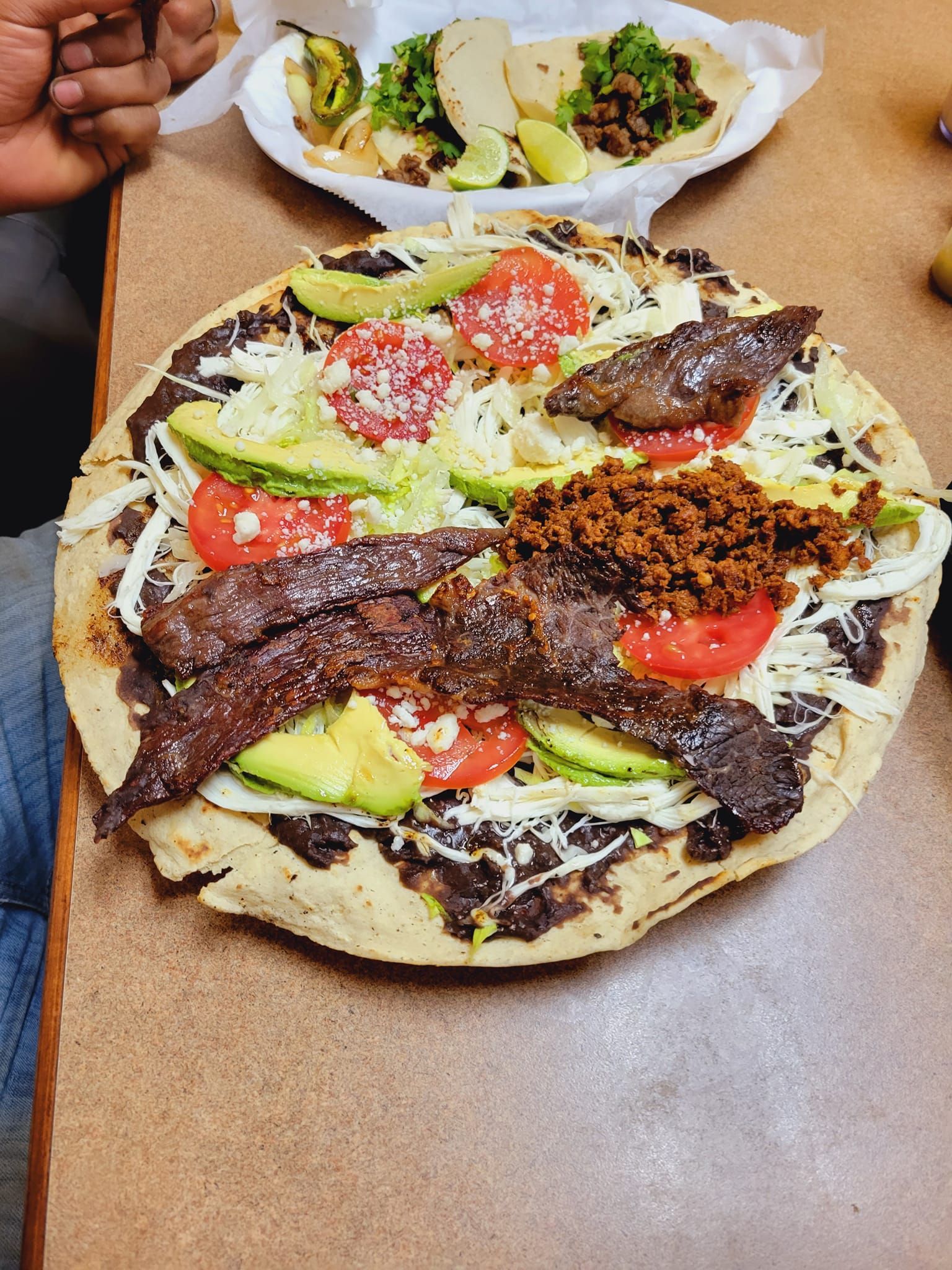 A pizza with a lot of toppings on it is on a table.