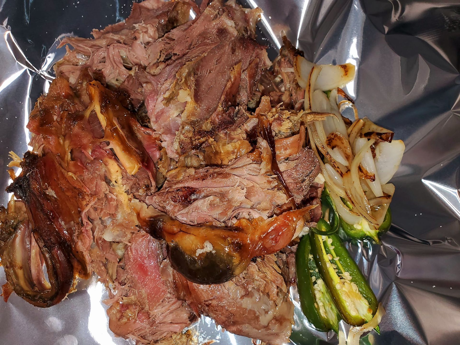 A piece of meat is sitting on top of a piece of tin foil.