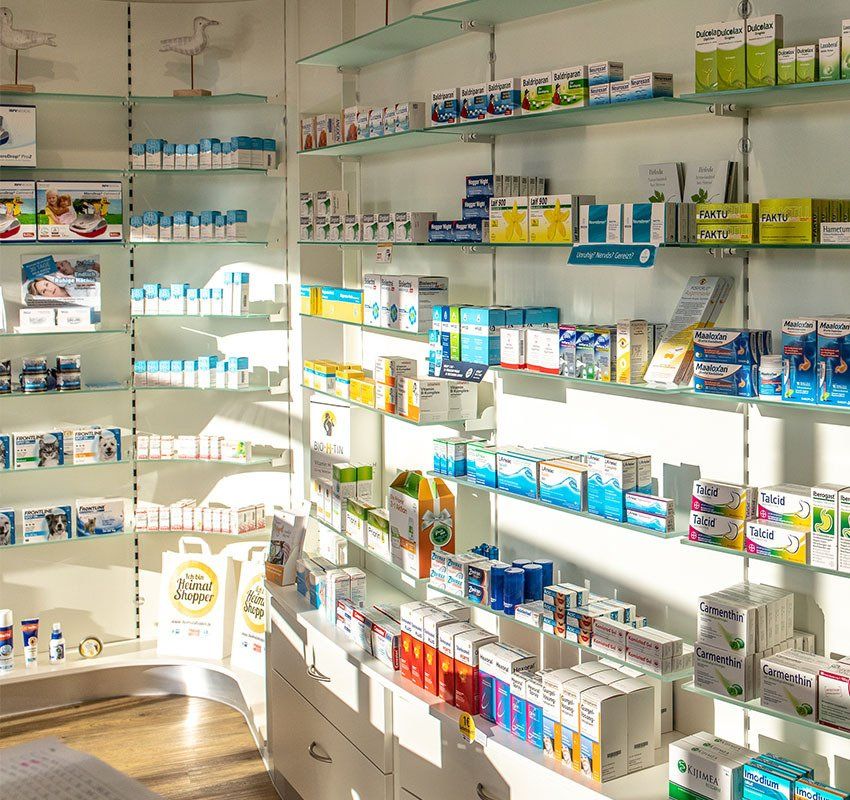 Apothekeninnenraum mit Regalen, die mit verschiedenen Schachteln voller Medikamente und Gesundheitsprodukte bestückt sind.