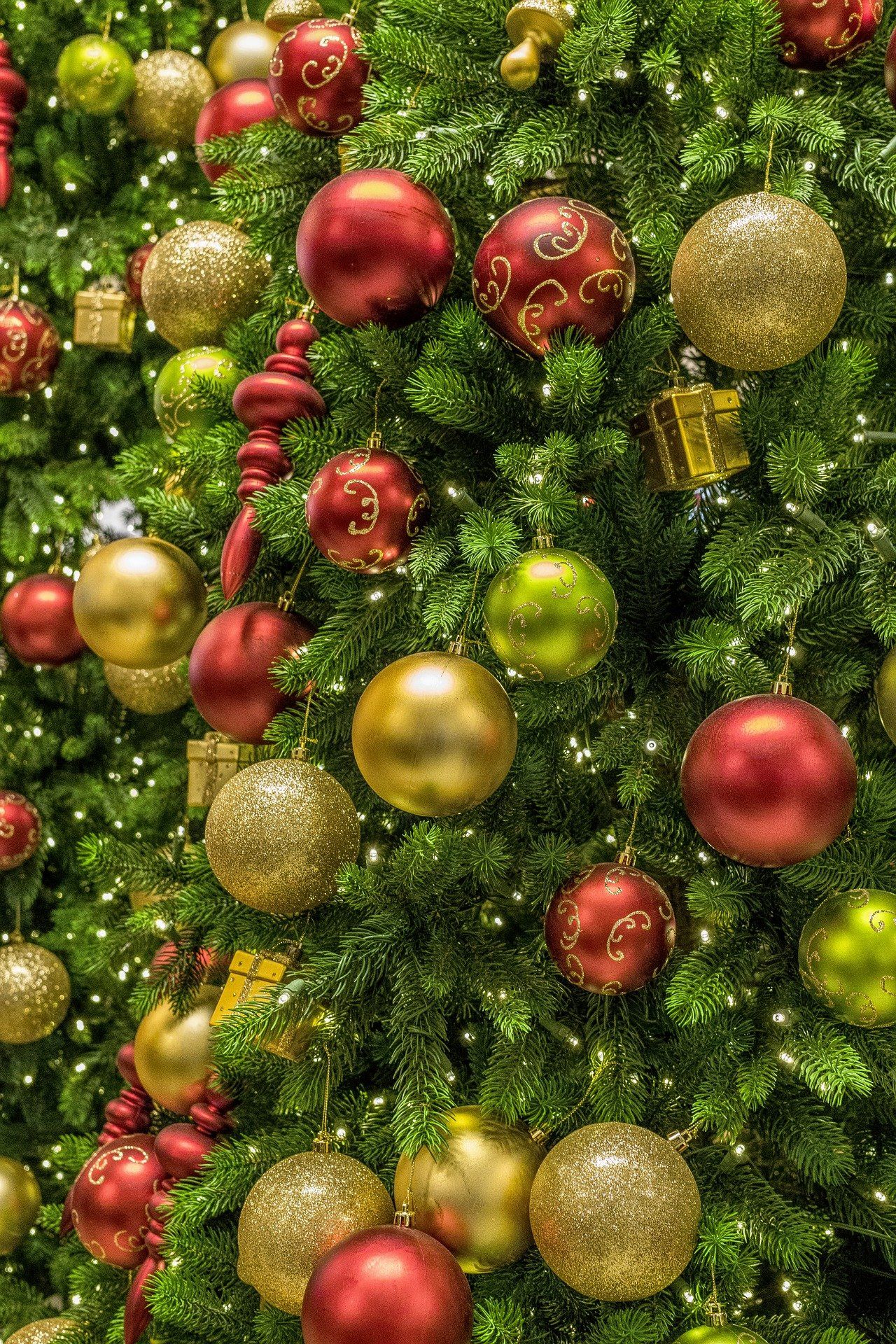 Ein Weihnachtsbaum, der mit roten und goldenen Kugeln und Lichtern geschmückt ist.