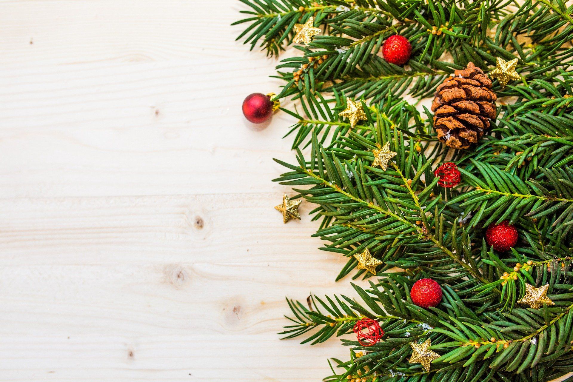 Ein geschmückter Weihnachtsbaum mit Tannenzapfen auf einem Holztisch.