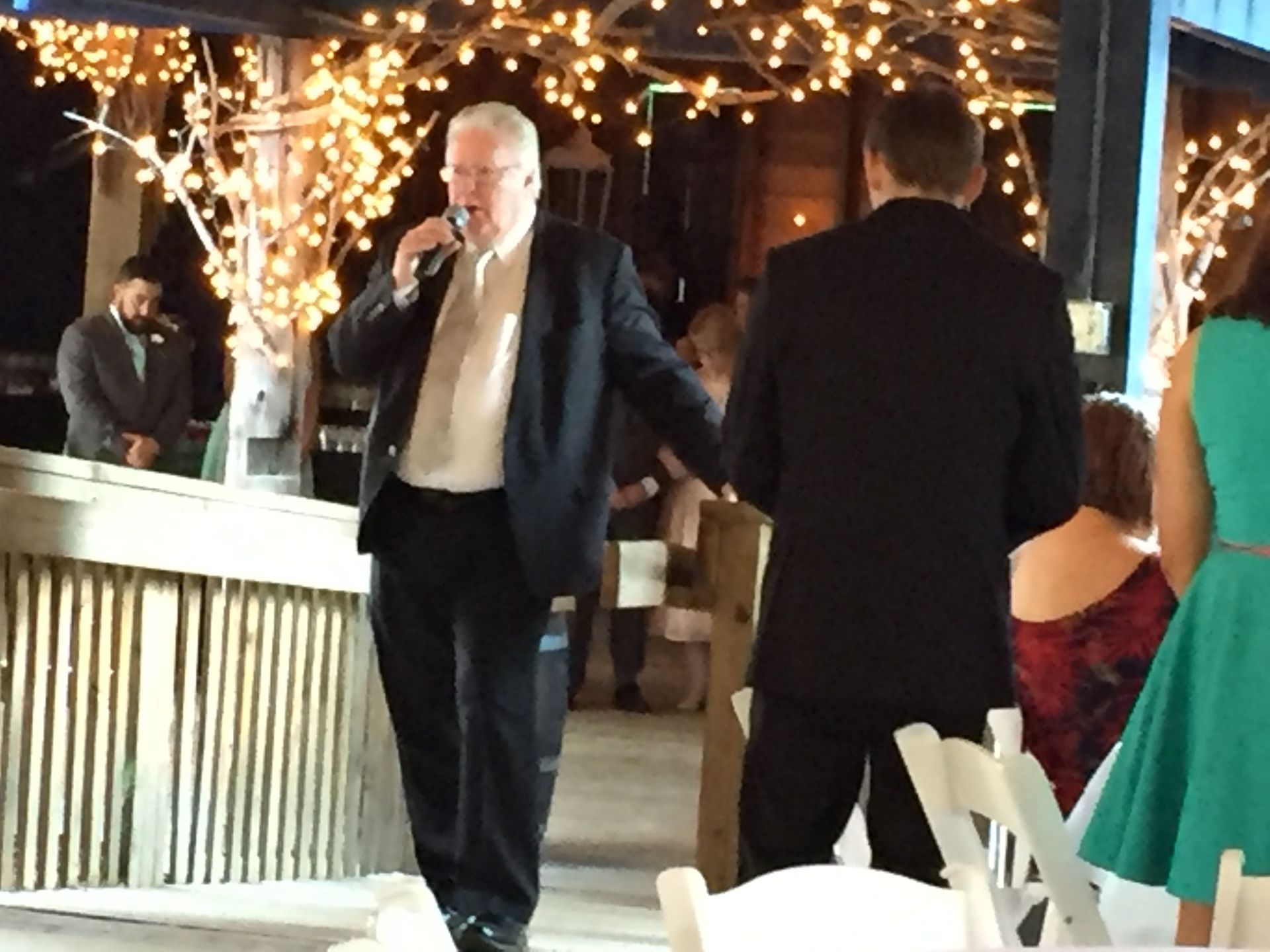 A man in a suit is singing into a microphone