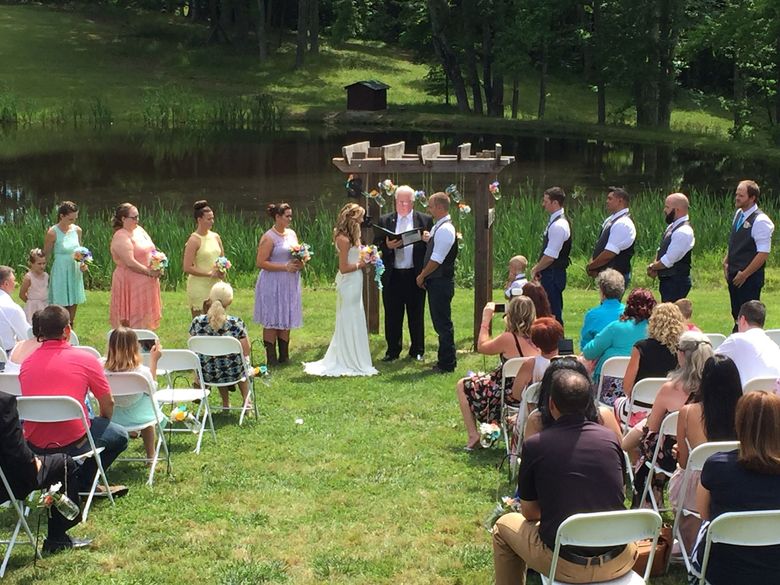 A bride and groom are getting married in front of a crowd of people.
