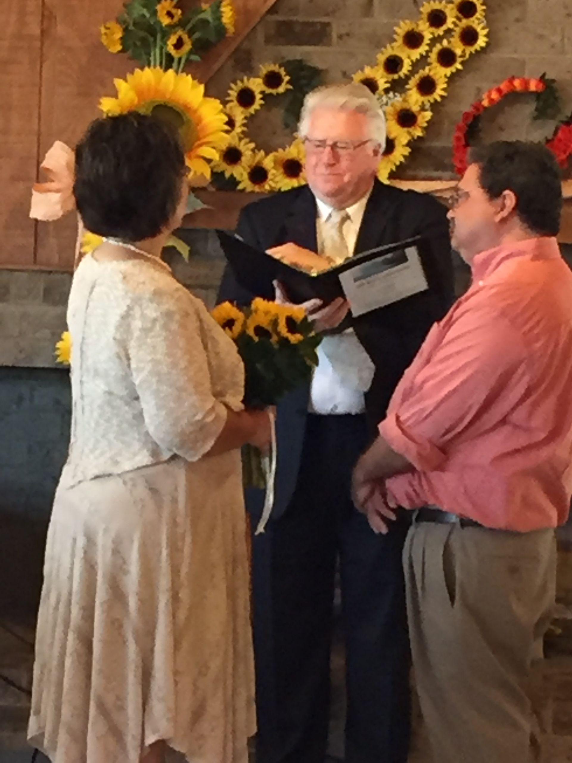 A man is reading a book to a bride and groom