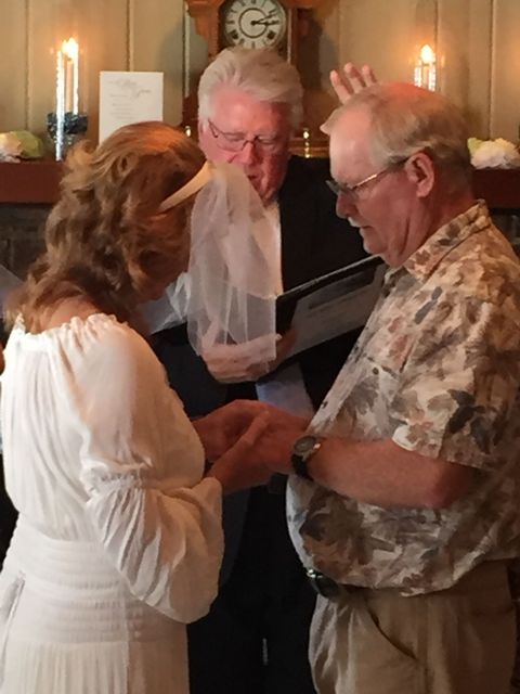 A man is putting a wedding ring on a woman 's finger