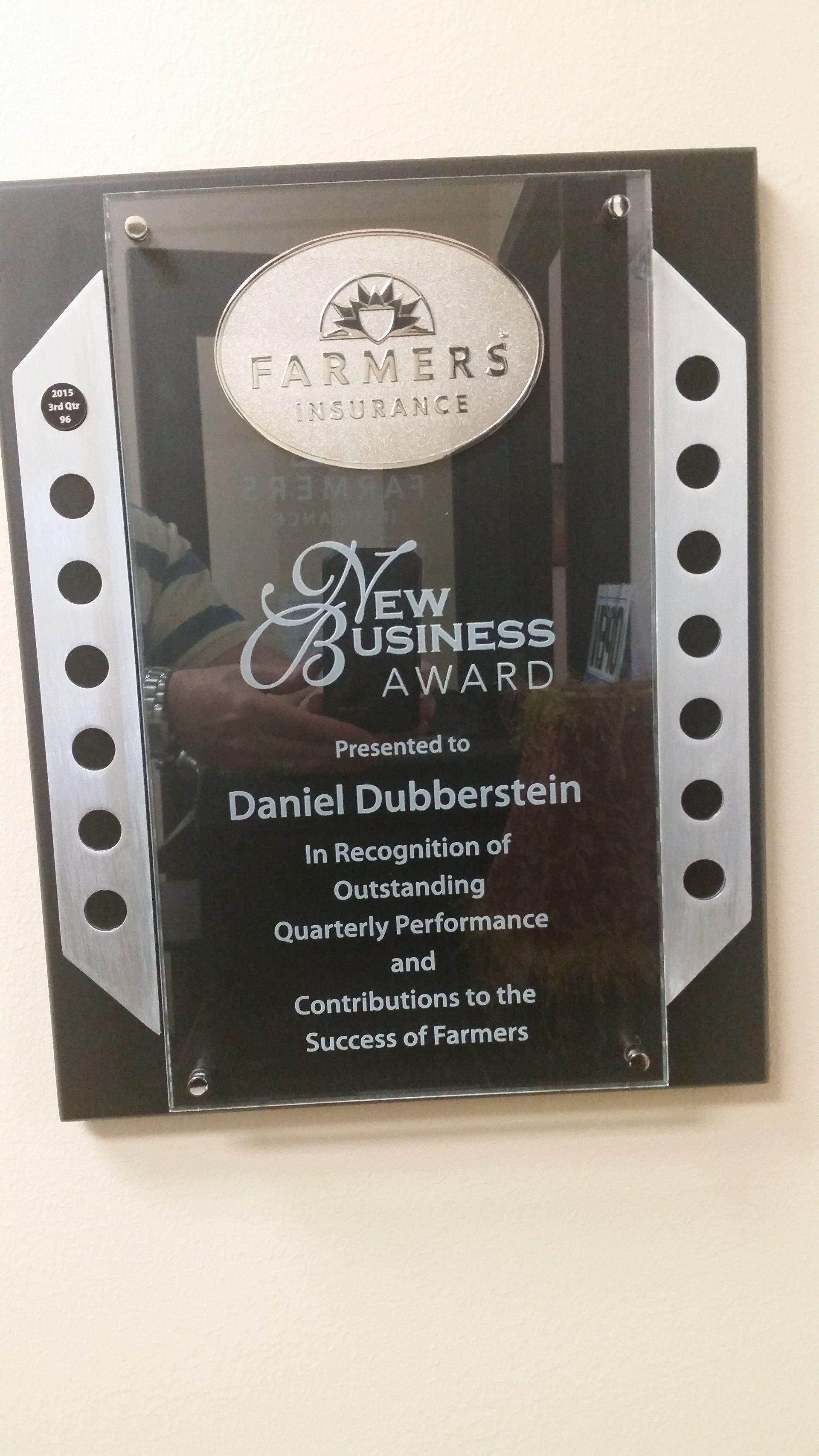 Framed Business Award plaque with black and silver design on a wall